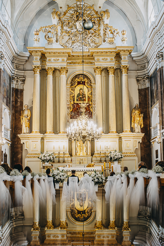 Fotografia ślubna pokazująca młodą parę w kościele