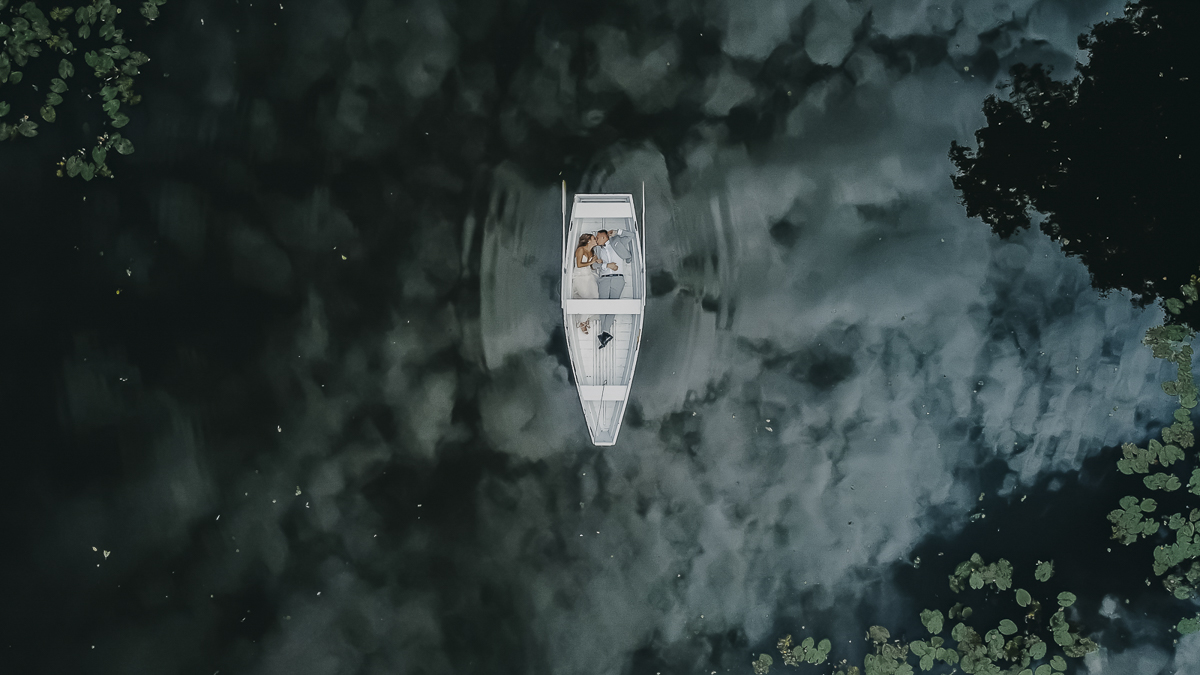 Fotografia ślubna pokazująca młodą parę na łódce